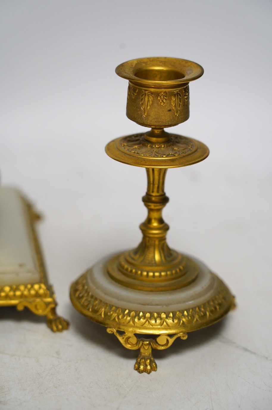 An early 20th century onyx and gilt metal desk set comprising inkwell and a pair of candlesticks, 13.5cm. Condition - fair to good